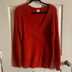 Red V-neck fuzzy sweater.